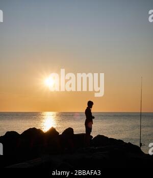 Vue sur une ombre de pêcheur sur les rochers de la côte de Punta Ballena sur la baie de Solanas, océan atlantique, Maldonado, Uruguay Banque D'Images