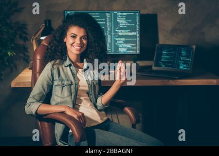 Portrait de positif habile afro american fille concepteur de Web chaise de siège profiter de son travail de données de compagnie de nuit des lunettes de conservation dans le lieu de travail Banque D'Images