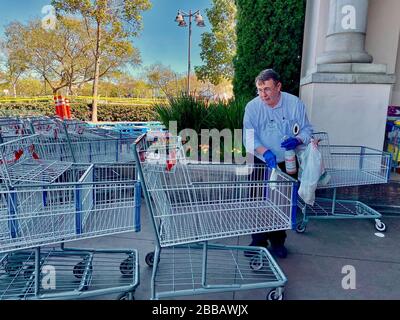 Santa Barbara, Californie, États-Unis. 27 mars 2020. Un employé efface les chariots de shopping à Costco à Goleta pendant la pandémie de Covid-19. Crédit: Amy Katz/ZUMA Wire/Alay Live News Banque D'Images