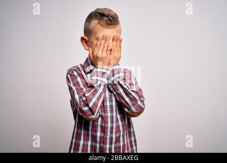 Jeune enfant caucasien avec des yeux bleus portant une élégante chemise debout sur des yeux isolés frottant d'arrière-plan pour la fatigue et les maux de tête, sommeil et TI Banque D'Images