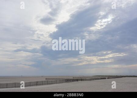 Jones Beach State Park, New York, États-Unis : l'escrime protège cette plage de long Island contre l'érosion du vent alors que les nuages se rassemblent au coucher du soleil. Banque D'Images