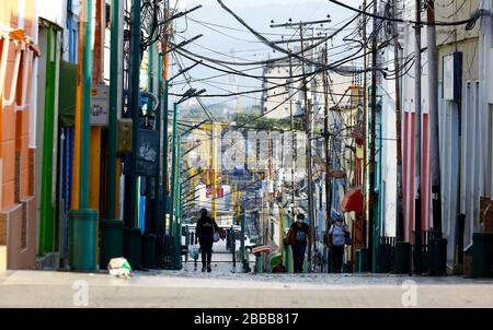 Valencia, Carabobo, Venezuela. 30 mars 2020. 30 mars 2020. Un peuple, tous deux portant des masques pour se protéger du Covid-19, promenez-vous dans le centre de la ville de Valence, Etat de Carabobo. Les rues sont gardées vides en raison de la conformité des citoyens à rester à la maison et ne partent qu'en cas d'urgence. Le Venezuela présente à ce jour 135 cas et seulement 3 personnes sont mortes. Photo: Juan Carlos Hernandez. Crédit: Juan Carlos Hernandez/ZUMA Wire/Alay Live News Banque D'Images