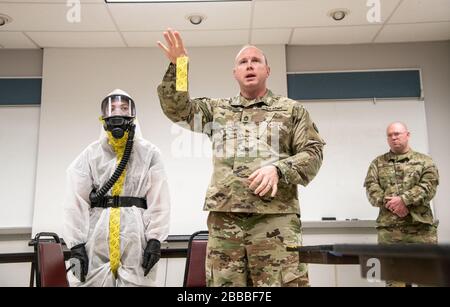 Les membres du Bataillon de la Garde nationale de Virginie-Occidentale (WVNG), chimique, biologique, radiologique, nucléaire et explosif à haut rendement (CBRNE), 35 e équipe de soutien civil (CST) et le 35ème groupe CBRN Enhanced Response Force Package (CERFP) fournissent des instructions pratiques sur les équipements de protection individuelle (EPI) aux membres des premiers organismes responsables du Kentucky et de Virginie-Occidentale, 16 mars 2020, à Huntington, en Virginie La formation juste à temps a été menée afin d'informer les premiers intervenants sur la façon de minimiser la contamination croisée par l'usure appropriée de l'EPI « doning » et les procédures de « déoffing ». (ÉTATS-UNIS Banque D'Images