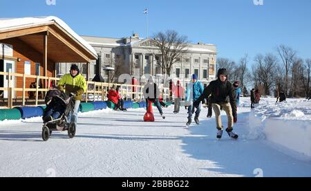 Patineurs sur un ovale de patinage sur glace dans le parc des plaines d'Abraham Battefields, Québec, Québec, Canada. À l'arrière-plan se trouve le pavillon principal (Gerard-Morisset) du Musée national des beaux-arts du Québec Banque D'Images