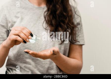 Vue rapprochée de la femme en utilisant un petit désinfectant pour les mains antibactérien portable sur les mains. Femme avec gel antiseptique antibactérien pour la désinfection des mains et la prévention de la protection de la santé pendant l'éclosion du virus de la grippe Banque D'Images