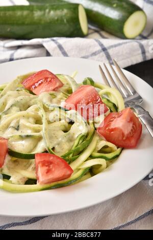 Pesto de basilic sauce alfredo sur courgettes spirales avec tomate Banque D'Images