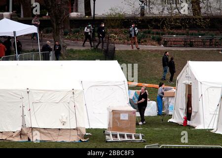 New York City, New York, États-Unis. 30 mars 2020.les travailleurs qui déchargent les fournitures et mettent la touche finale à un hôpital d'urgence dans le Central Park de New York pour faire face à la pandémie de coronavirus. L'organisation chrétienne basée en Caroline du Nord Samaritan's Purse a commencé à construire un hôpital d'urgence de 68 lits en face de l'hôpital Mount Sinai hier et il devrait être opérationnel le mardi 31 mars. L'hôpital de terrain sera composé d'une unité de soins respiratoires dotée de la capacité de l'unité de soins intensifs. Crédit: Adam Stoltman/Alay Live News Banque D'Images