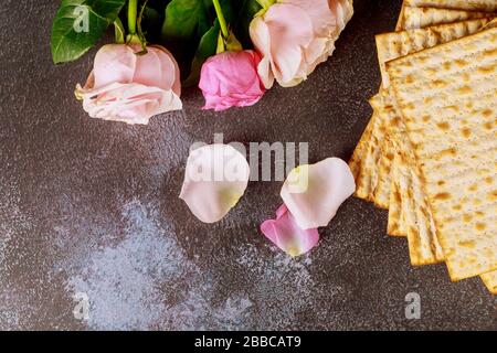 Fête juive symbolique célébration de la Pâque de Pesah avec pain sans levain matzo de fleur rose fraîche Banque D'Images