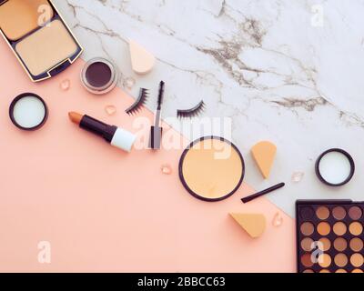 Espace de travail de blogger de la beauté de mode féminin. Outils de maquillage, produits cosmétiques, isolés sur deux arrière-plan couleur marbre et pêche rose avec copie Banque D'Images