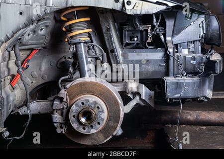 Vue d'une voiture démontée, suspension. Gros plan d'un moyeu de voiture, d'un étrier de frein, de plaquettes de frein, d'un disque de frein, d'un roulement de roue préparé pour la réparation. Travailler au t Banque D'Images