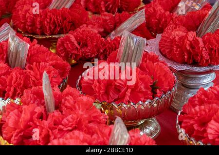 Une ligne de fleur rouge dans un bol, temple bouddhiste, wat Samphran, Thaïlande. Banque D'Images