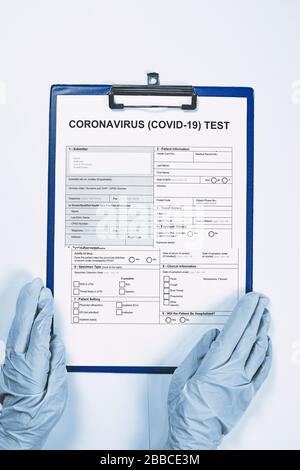 Mains d'un médecin ou d'une infirmière non reconnaissable remplissant le formulaire de test du coronavirus. Obtenez le test COVID-19. Test pour 2019-ncov. Formulaire de test médical pour nouveau coronavirus Banque D'Images