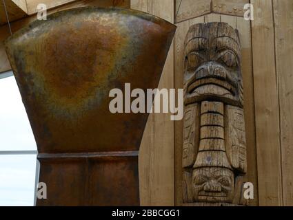 Cuivre et vieux totem dans le hall du Haida Heritage Centre à Kay Llnagaay, Skidegate, Haida Gwaii, anciennement connu sous le nom d'îles de la Reine-Charlotte, Colombie-Britannique, Canada Banque D'Images