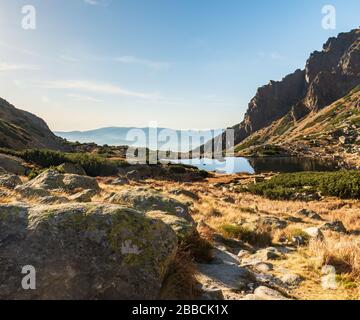 Lac Pleso nad Skokom avec sentier de randonnée et pics dans les montagnes Vysoke Tatry avec chaîne de montagnes Nizke Tatry sur fond de fond de la Slovaquie Banque D'Images