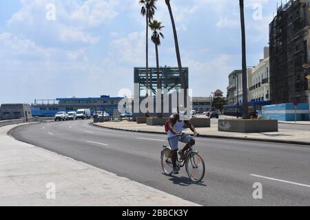 La Havane, Cuba. 30 mars 2020. Un homme portant un masque fait du vélo dans la rue à la Havane, Cuba, le 30 mars 2020. Crédit: Zhu Wanjun/Xinhua/Alay Live News Banque D'Images