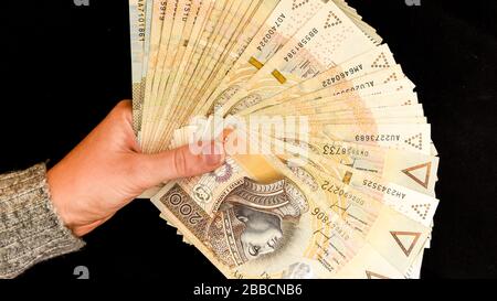 monnaie zloty polonaise, tenant main polish zloty argent sur le fond noir Banque D'Images