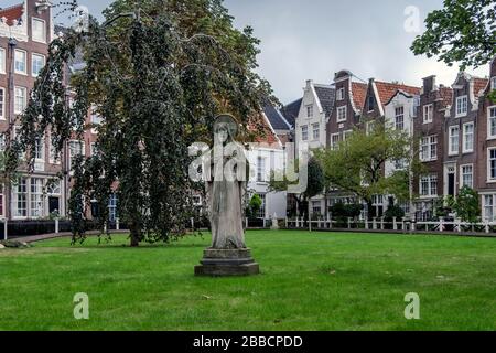Statue de Jésus-Christ à Begijnhof entourée de maisons historiques à Amsterdam, aux Pays-Bas Banque D'Images