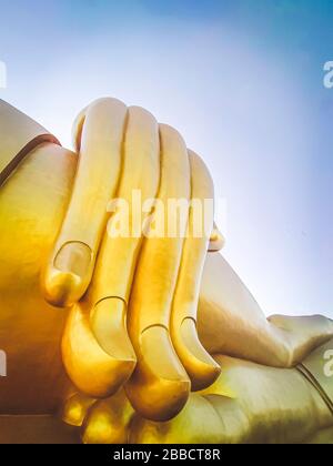 Gros plan de la grande statue de Bouddha avec le ciel bleu à Wat Tha Muang Thaïlande. Les statues de Bouddha d'or les plus emblématiques Banque D'Images