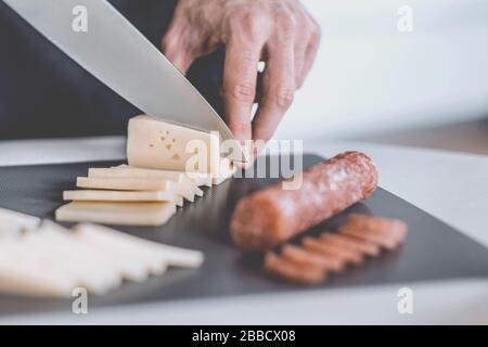 Close up. man slicing pour sandwich au fromage Banque D'Images