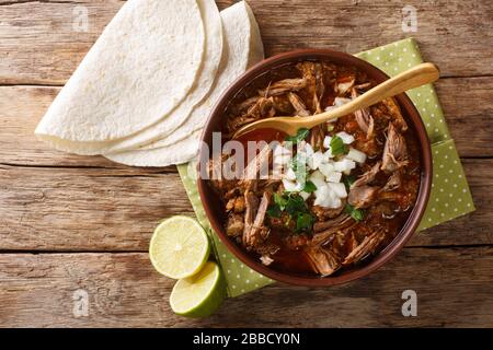 Le ragoût de bœuf cuit lentement de style mexicain Birria de Res servi avec de la chaux et de la tortilla dans un bol sur la table. Vue de dessus horizontale Banque D'Images