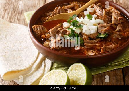 Style mexicain ragoût de bœuf cuit lentement Birria de Res servi avec de la chaux et de la tortilla dans un bol sur la table. Horizontal Banque D'Images