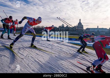 Des hommes qui font des courses à la FIS cross-country ski sprint World Cup sur les rives de la rivière Elbe, la ligne d'horizon de la ville baroque au loin Banque D'Images