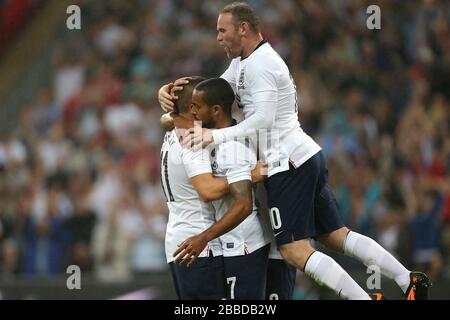 Theo Walcott (centre), en Angleterre, célèbre la notation de son premier but du jeu avec ses coéquipiers Wayne Rooney (à droite) et Tom Cleverley Banque D'Images