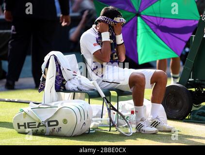 Les serviettes Novak Djokovic de Serbie lui-même lors d'un changement de fin dans son match contre Juan Martin Del Potro d'Argentine Banque D'Images