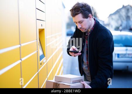 Un homme apporte des colis à une station d'emballage ou les prend Banque D'Images