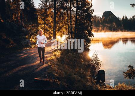 Sport et style de vie sain concept: Silhouette d'un homme qui courir pendant un lever de soleil brumeux dans la campagne Banque D'Images