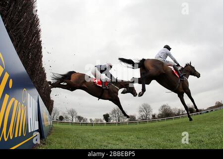 Le surf est monté par Barry Geraghty (R) et M. Moonshine, monté par Henry Oliver en action lors du chasse de Betfred Peterborough à l'hippodrome de Huntingdon, Banque D'Images