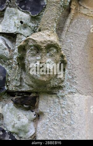 Sculpture en pierre d'un visage sur l'extérieur de l'église St Pierre et St Paul à Newnham près de Sittingbourne dans le Kent, en Angleterre Banque D'Images