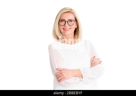 Portrait photo d'une femme blonde souriante debout avec des bras croisés sur fond blanc isolé. Banque D'Images