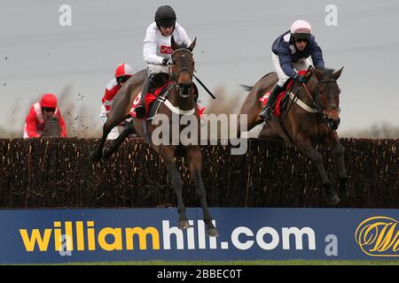 Le surf est monté par Barry Geraghty (L) et M. Moonshine, monté par Henry Oliver en action lors du chasse de Betfred Peterborough à l'hippodrome de Huntingdon, Banque D'Images