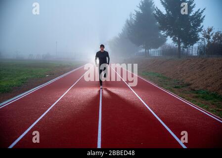 Photo de concept de course à pied. Silhouette d'athlète, homme actif courir et sauter le matin au-dessus du ciel bleu misty. Photo sport, espace de montage Banque D'Images