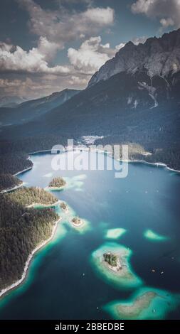 Vue aérienne prise par un drone de l'Eibsee avec des îles et des arbres sur la rive du lac Banque D'Images