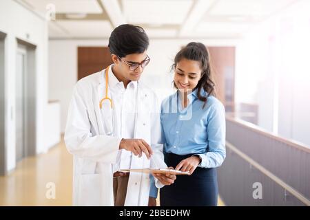 Deux jeunes médecins discutent de quelque chose dans le couloir d'un hôpital Banque D'Images