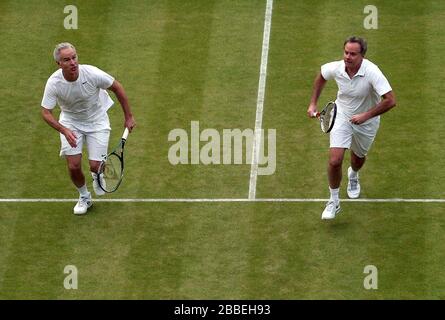 John McEnroe (à gauche) en action avec le partenaire Patrick McEnroe (à droite) contre Paul McNamee et Peter McNamara, en Australie, lors du match de Double invitation senior de leurs messieurs, le huitième jour de Wimbledon, organisé au All England Lawn tennis and Croquet Club Banque D'Images