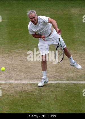 John McEnroe des États-Unis en action avec le partenaire Patrick McEnroe contre Paul McNamee et Peter McNamara de l'Australie lors du match de Double invitation senior de leurs messieurs au cours du huitième jour de Wimbledon tenu au All England Lawn tennis and Croquet Club Banque D'Images