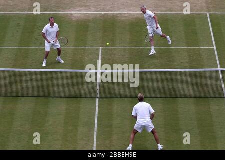 John McEnroe des États-Unis (à droite) en action avec le partenaire Patrick McEnroe (à gauche) contre Paul McNamee et Peter McNamara (au centre) de l'Australie lors du match de Double invitation senior de leurs Messieurs, le huitième jour de Wimbledon, organisé au All England Lawn tennis and Croquet Club Banque D'Images