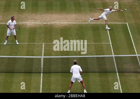 John McEnroe des États-Unis (à droite) en action avec le partenaire Patrick McEnroe (à gauche) contre Paul McNamee et Peter McNamara (au centre) de l'Australie lors du match de Double invitation senior de leurs Messieurs, le huitième jour de Wimbledon, organisé au All England Lawn tennis and Croquet Club Banque D'Images