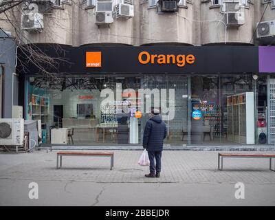 CHISINAU, MOLDAVIE-17 MARS 2020: Un homme âgé se tient devant un Orange Moldavie Shop fermé en quarantaine. Banque D'Images