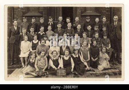 Début des années 1900 carte postale d'enfants juniors (standard 6 et 7) se posant à l'extérieur pour la photo, l'école de St. Andrew, Homer Street, Manchester, Angleterre, Royaume-Uni date de mai 1934 Banque D'Images