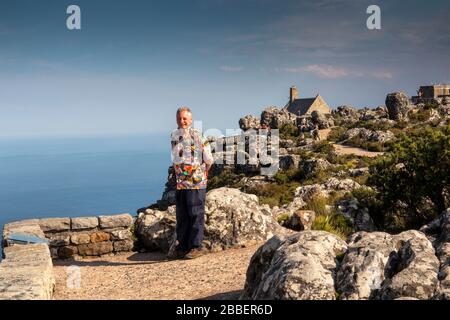 Afrique du Sud, le Cap, Tafelberg Road, Table Mountain, touriste senior dans une chemise colorée sur un sentier rocheux à la station aérienne café et boutique Banque D'Images