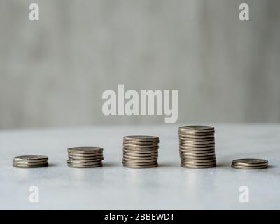 Colonnes de pièces de monnaie ascendante suivies d'une chute soudaine et nette avec espace de copie. Concept illustratif de crash de marché, de récession soudaine ou de los financiers soudains Banque D'Images