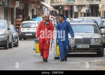 Beyrouth, Liban. 31 mars 2020. Une équipe de professionnels du nettoyage portant des combinaisons de protection contre les hazmat vaporise du désinfectant autour des locaux de la boutique dans la rue Hamra de Beyrouth comme mesures de protection contre la propagation du coronavirus nouveau covid-19. Crédit: amer ghazzal/Alay Live News Banque D'Images