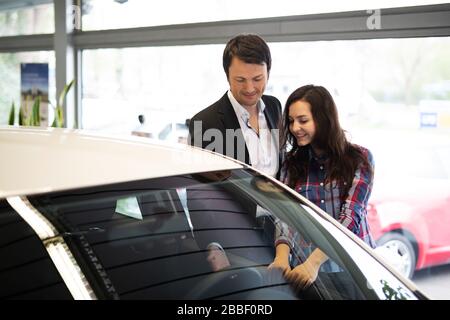 Le vendeur de voiture montre à un client une nouvelle voiture Banque D'Images