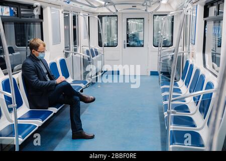 L'homme utilise un masque médical, se trouve seul dans le métro, les transports en commun, évite le covid-19, utilise des équipements pour rester en sécurité pendant la durée de vie Banque D'Images