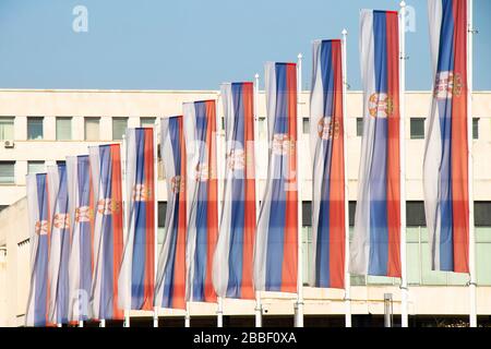 Belgrade, Serbie - 20 mars 2020: Drapeaux nationaux serbes sur les poteaux devant le Palais de Serbie, un bâtiment gouvernemental situé à New Belgrade Banque D'Images