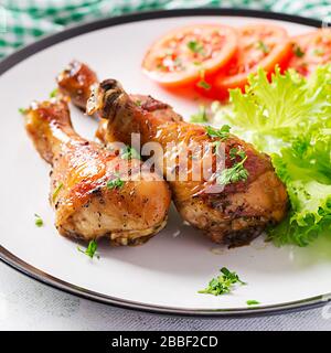 Pattes de poulet grillées aux épices et légumes frais. Pilons cuits au four. Banque D'Images